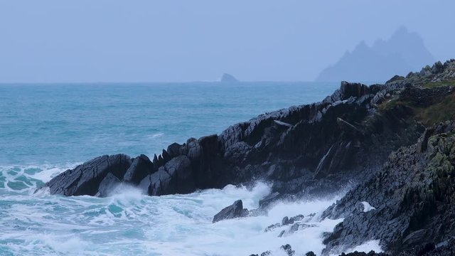 footage of skellig michael in the ring of kerry off the coast of ireland on the wild atlantic way showing crashing waves on black rock and beach