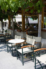 Street cafe with white tables and chairs. Olimpia