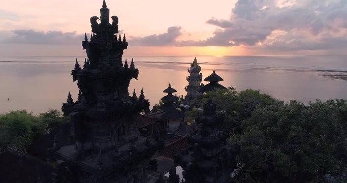 Aerial top view of Pura Geger temple at sunrise on the ocean, Bali. 4K