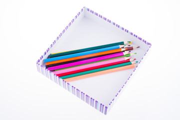 bright multi-colored pencils in a striped box. kids art