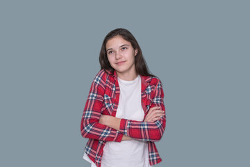 portrait of a young girl shrugging, gray wall background