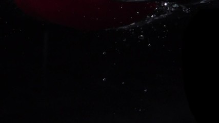Red bell pepper falls into water. Slow motion. Black background. Food video - Powered by Adobe