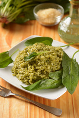 Italian risotto with spinach in the white dish - vegetarian recipe - closeup