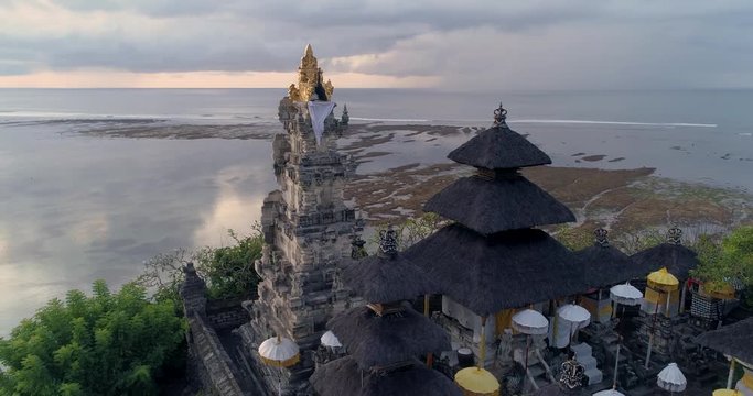 Aerial top view of Pura Geger temple at sunrise on the ocean, Bali. 4K