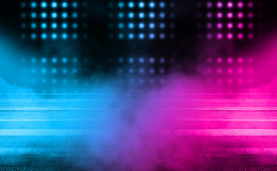 Dark empty stage, blue and orange neon spotlight, wet asphalt, smoke, night shooting, rays