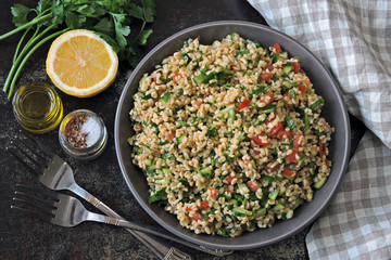 Arabic salad tabbouleh in a bowl. Middle Eastern cuisine. Healthy salad with bulgur, parsley and...