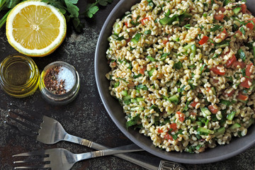 Arabic salad tabbouleh in a bowl. Middle Eastern cuisine. Healthy salad with bulgur, parsley and...