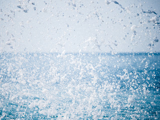 Splashes of water against the sea on a sunny summer day
