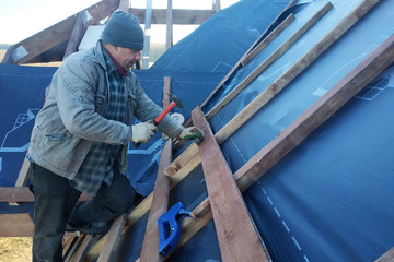 The master clogs the nail into a beam, fixing this gidrorizer to the rafters