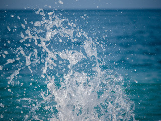 Splashes of water against the sea on a sunny summer day