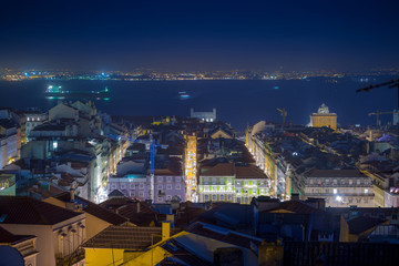 Night long exposure aerial cityscape. View of historic central quarters, Commerce Square, Triumphal Rua Augusta Arch and Tagus river in evening illumination, Lisbon, Portugal.