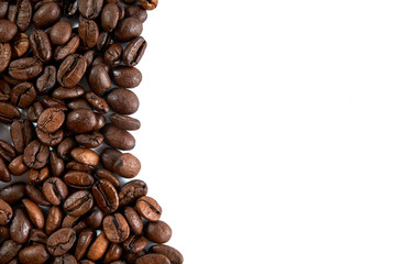 Coffee grains scattered on a white background with a place for an inscription.