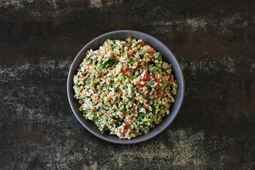 Arabic salad tabbouleh in a bowl. Middle Eastern cuisine. Healthy salad with bulgur, parsley and vegetables. Vegan salad with bulgur. Tabouli salad