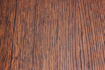 Dark wooden texture background of vibrant walnut brown colored wood. Empty timber material table surface, blank backdrop for copy space. Oak parquet pattern canvas, rustic woodwork wallpaper close up