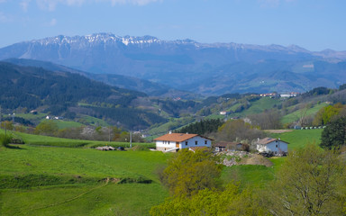 Fototapeta na wymiar landscape view of green meadows mountains and a small farm, Basque Country, Spain
