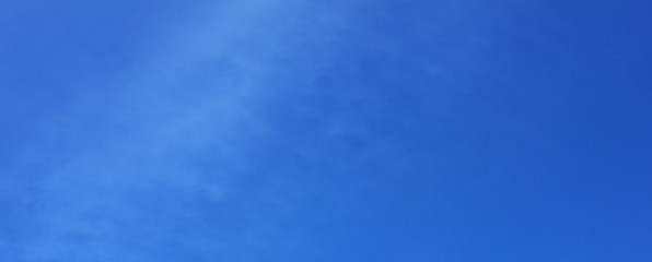 Blue sky empty background with no clouds. Elongated clear banner of light bright blue sky cloudless texture with blank copy space