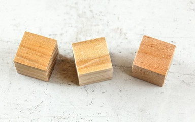 Three empty wood playing cube blocks on white board