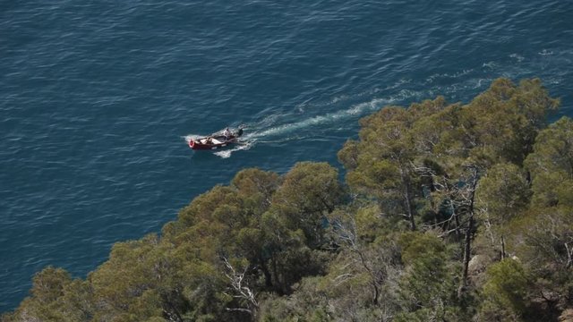 Bonassola, near Cinque Terre, Liguria. A boat in the blue sea seen from an overhanging rock. The promontory called "Salto della Lepre" offers a breathtaking view of the open sea of the Five Lands.