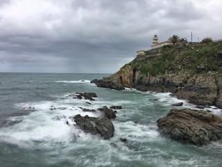 Fototapeta na wymiar Puerto de Cudillero un día nublado con marejada