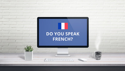 Concept of French language learning online. Question Do you speak French wih French flag on a computer display on work desk.