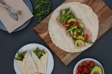 Cooking healthy avocado and vegetables burrito, wraps, rolles. Healthy breakfast or snack. Avocado sandwich. Copy space.