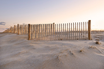 Sand Dune, Fence, and Sky Glowing at Sunrise in Cape Cod.