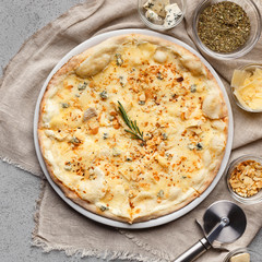 Pizza quattro fromaggi decorated with chopped nuts closeup