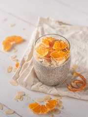 Chia seeds dessert with milk and citrus orange on white background.