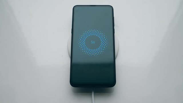 Male user places a phone onto induction charging station. Wireless charging concept.