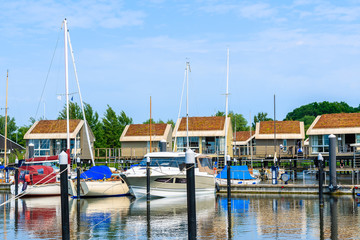Fototapeta na wymiar Boats mooring in Lauterbach port with houses on water on sunny summer day, Ruegen island, Baltic Sea, Germany