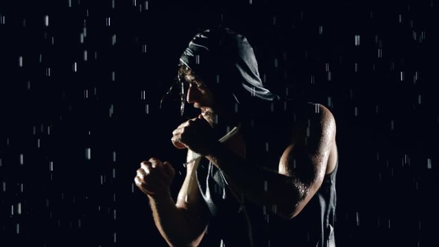 Athletic man shadow boxing in the rain.