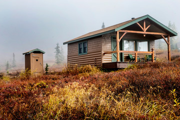 Fototapeta na wymiar A little cabin in Alaska with an outside bathroom.