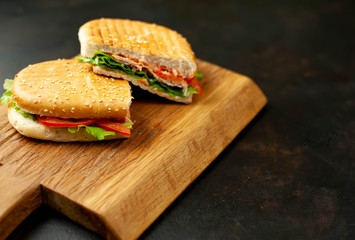 sandwich on a cutting board against a background of stone