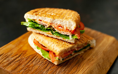 sandwich on a cutting board against a background of stone