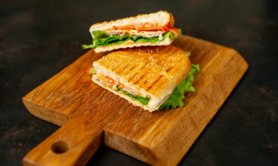 sandwich on a cutting board against a background of stone