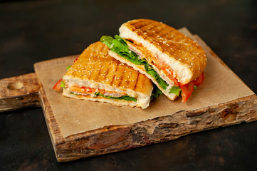 sandwich on a cutting board against a background of stone