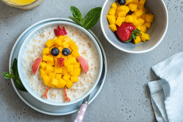 Funny bowls with oat porridge with bunny, chick and flower for Easter