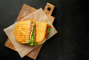 sandwich on a cutting board against a background of stone