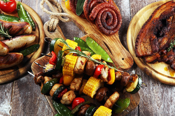 Assorted delicious grilled meat and skewer with vegetable on rustic table