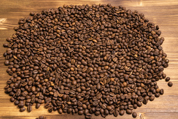 Roasted coffee beans in bulk on a wooden background