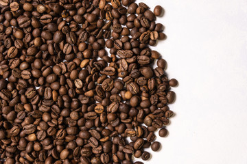 Roasted coffee beans in bulk on a light blue background. dark cofee roasted grain flavor aroma cafe, natural coffe shop background, top view from above, copy space