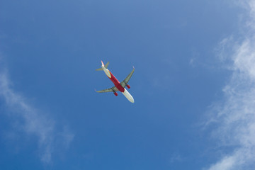Passenger plane flying in the blue sunny sky