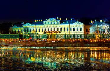 historical building Sheremetyev Palace of St. Petersburg on the embankment with Christmas lights, fairytale night picture of the historic Cneter.