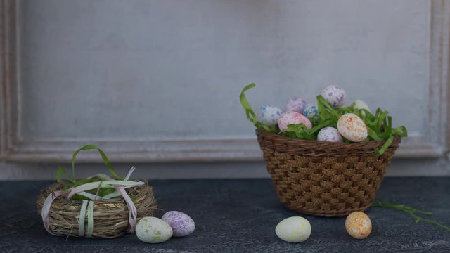 Painted ester eggs in a basket. White vintage wall in background. Copy space.