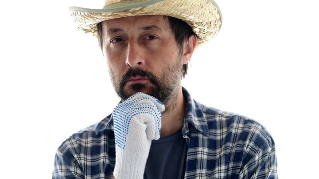 Portrait of thoughtful farmer in contemplative pose with hand on his chin isolated on white background.