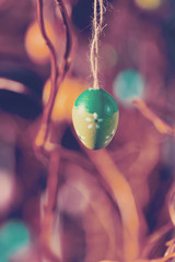 Hanging Easter eggs on tree with soft focus bokeh and color toned. Spring easter concept background.