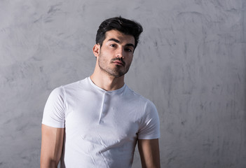 A serious young man in a white tshirt