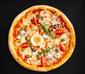 seafood pizza on the black background