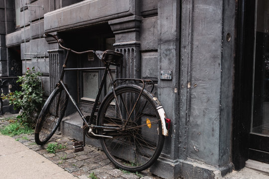 Sehr altes schwarzes Fahrrad lehnt an sch&ouml;ner alter Hauswand 