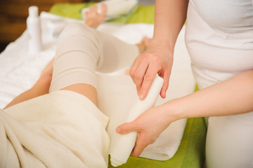 Anti-cellulite wraps procedure for legs in a spa center